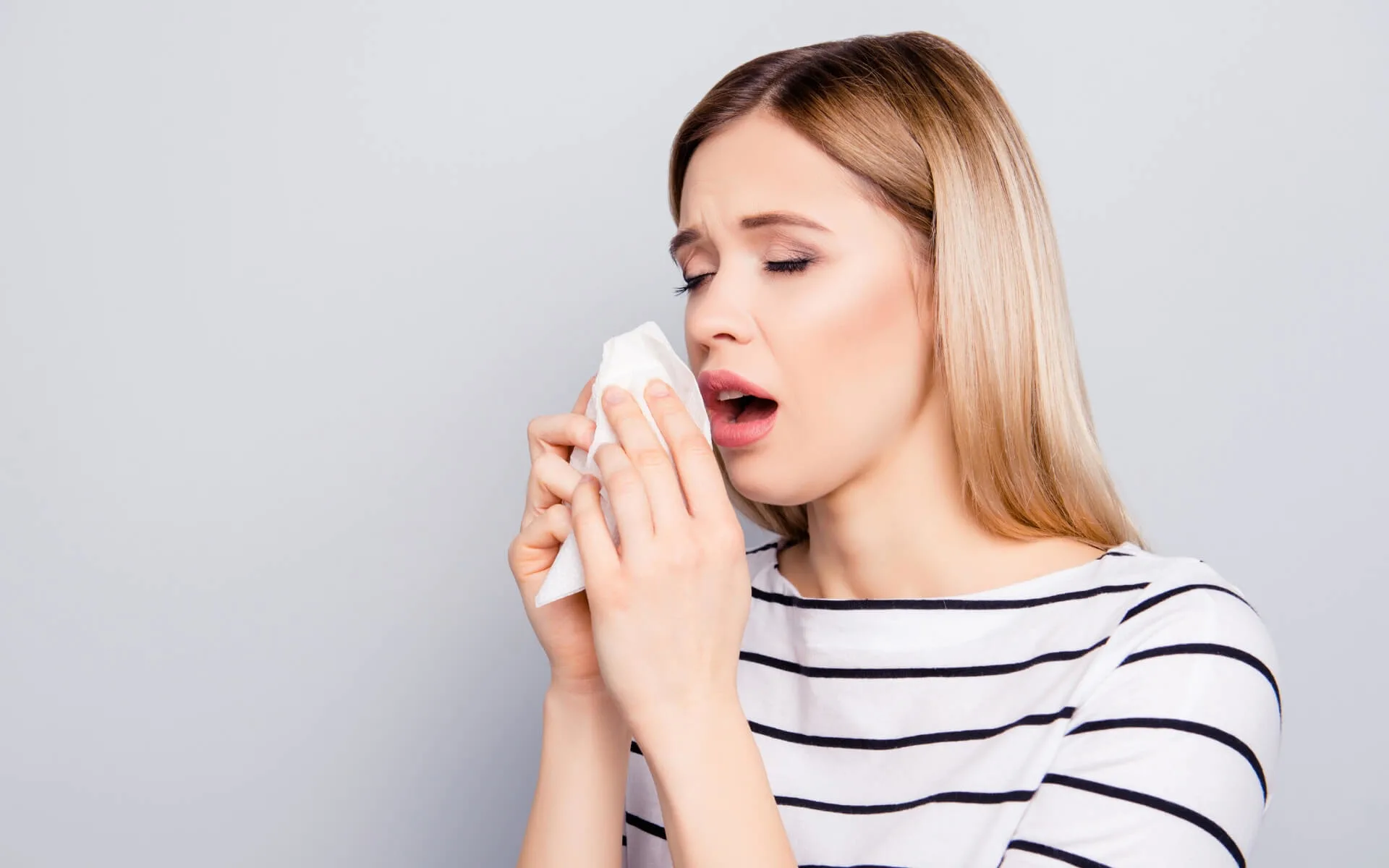 Frau niest wegen einer Winterallergie