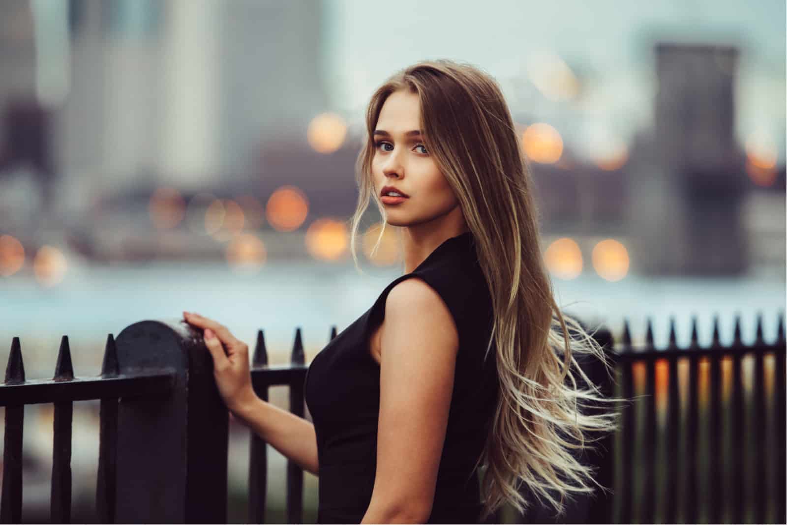 eine schöne Frau mit langen braunen Haaren in einem schwarzen Kleid