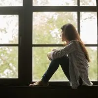 Frau sitzt am Fenster