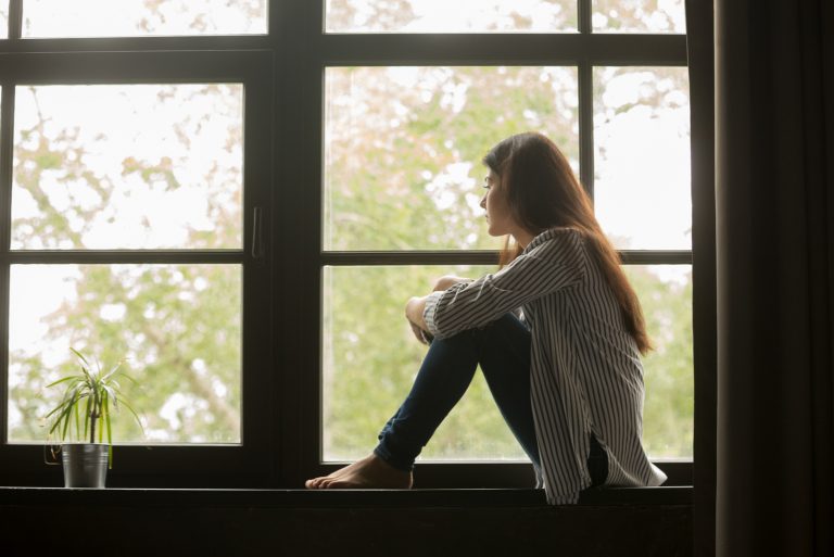 Frau sitzt am Fenster