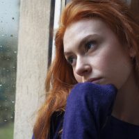 Eine imaginäre rothaarige Frau schaut aus dem Fenster