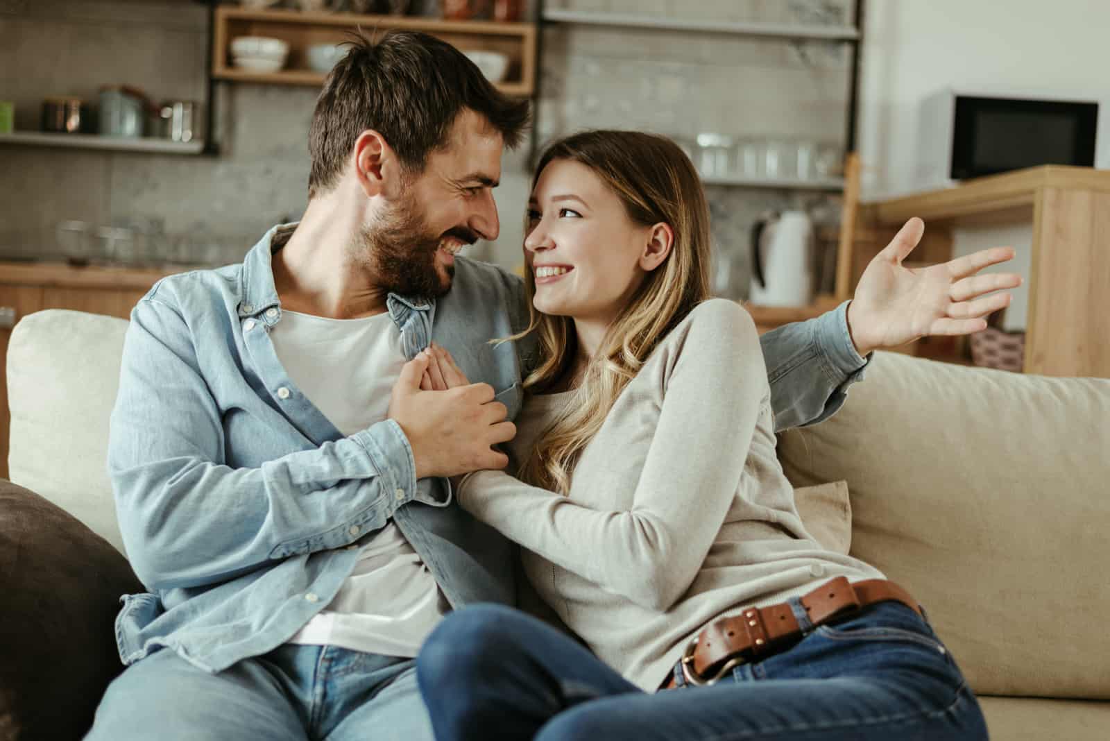 Liebevolles glückliches Paar, das zu Hause miteinander redet
