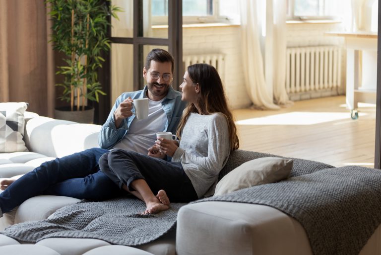 Liebespaar, das auf gemütlichem Sofa im Wohnzimmer entspannt