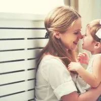 Mutter und Kind Mädchen spielen, küssen und umarmen