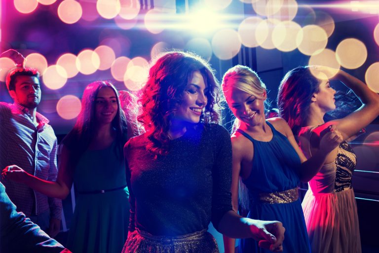 lächelnde Freunde tanzen im Club