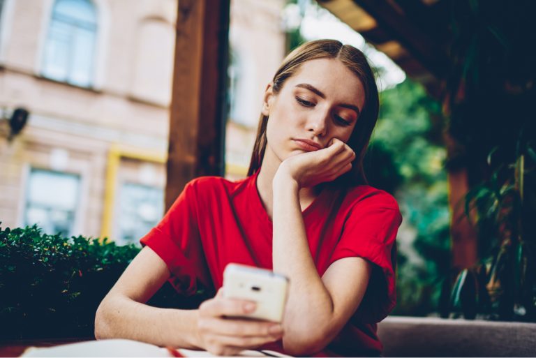 worried woman looking at mobile phone