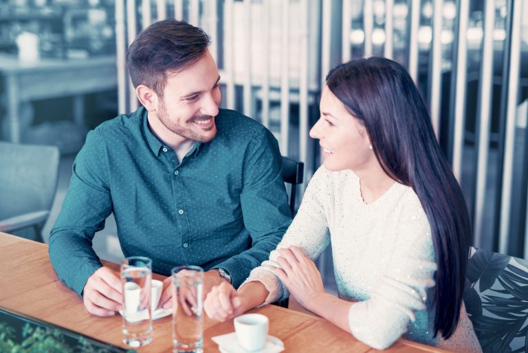 ein mann und eine frau sitzen zusammen und unterhalten sich beim kaffee
