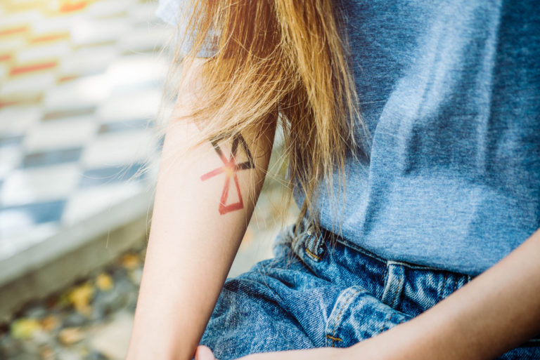 eine blonde Frau mit einem Tattoo auf dem Arm