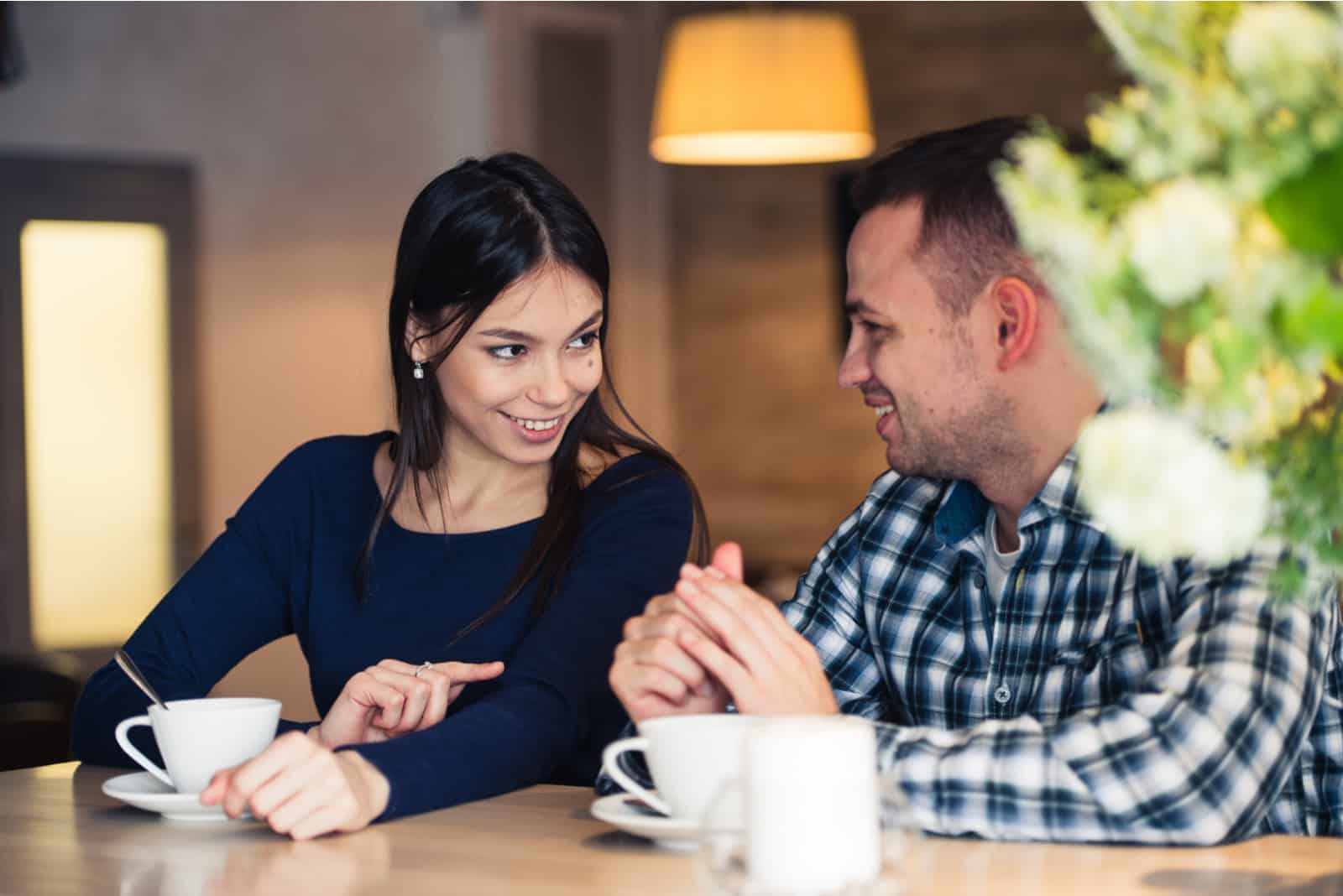 Ein lächelnder Mann und eine Frau sitzen nebeneinander und unterhalten sich