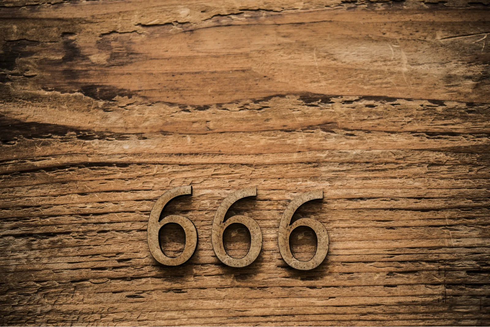Nummer 666 auf einem Holzsockel geschnitzt