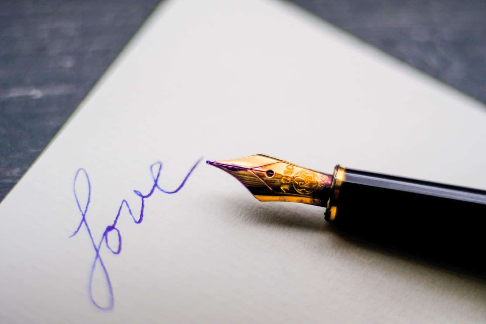 Stift mit dem Wort Liebe auf Papier geschrieben