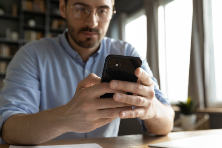 mann, der einen text auf seinem telefon eingibt