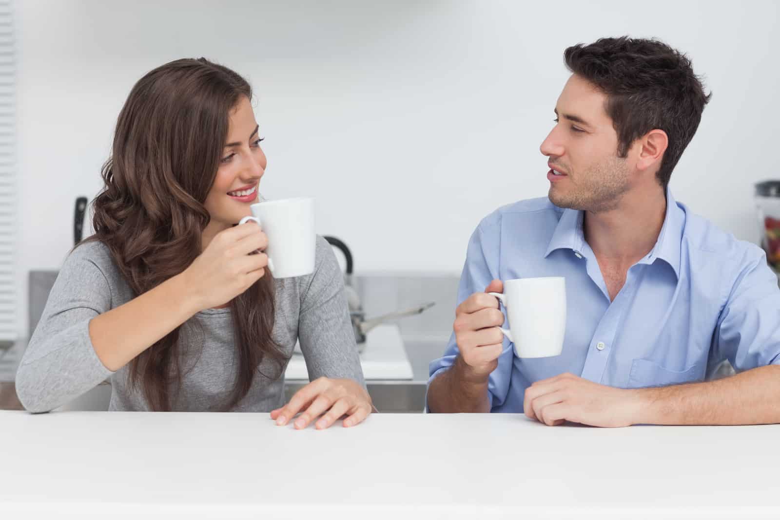 Ein Mann und eine Frau sitzen an einem Tisch und unterhalten sich bei einem Kaffee