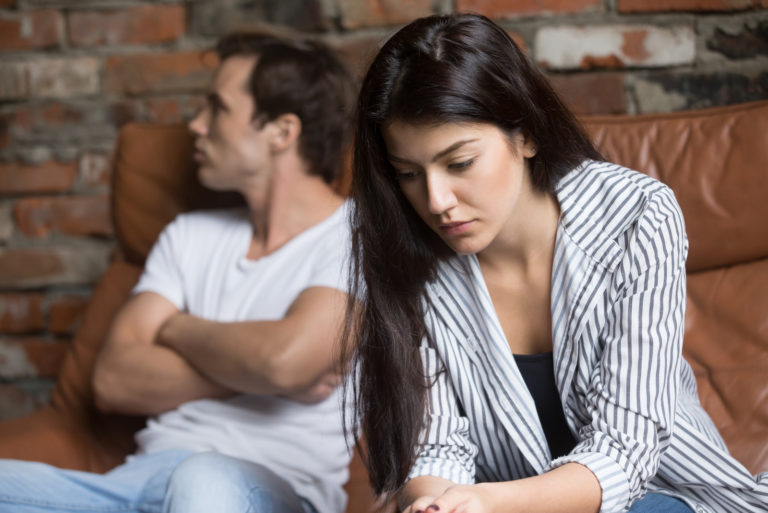 traurige frau, die mit mann auf der couch sitzt