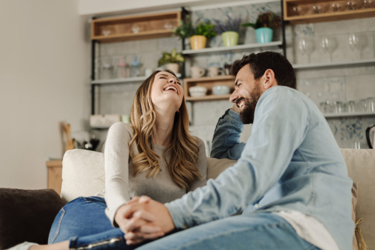 Glückliches Paar, das auf dem Sofa lacht
