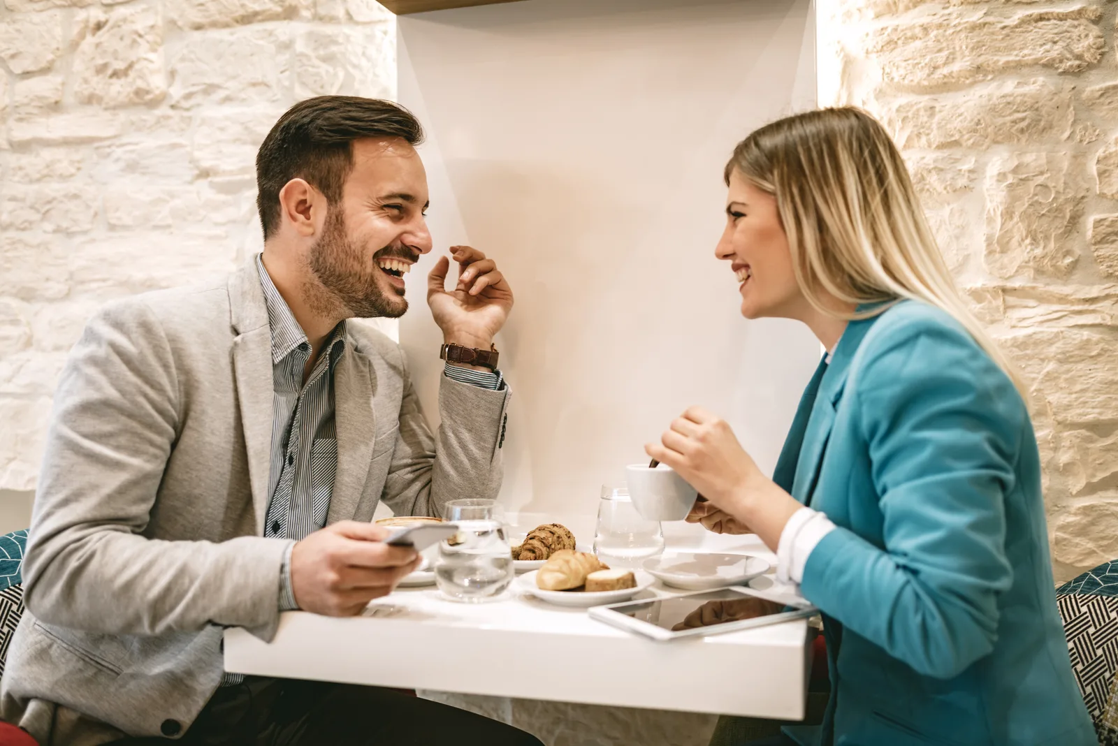 ein lächelnder Mann und eine Frau, die sich beim Essen unterhalten