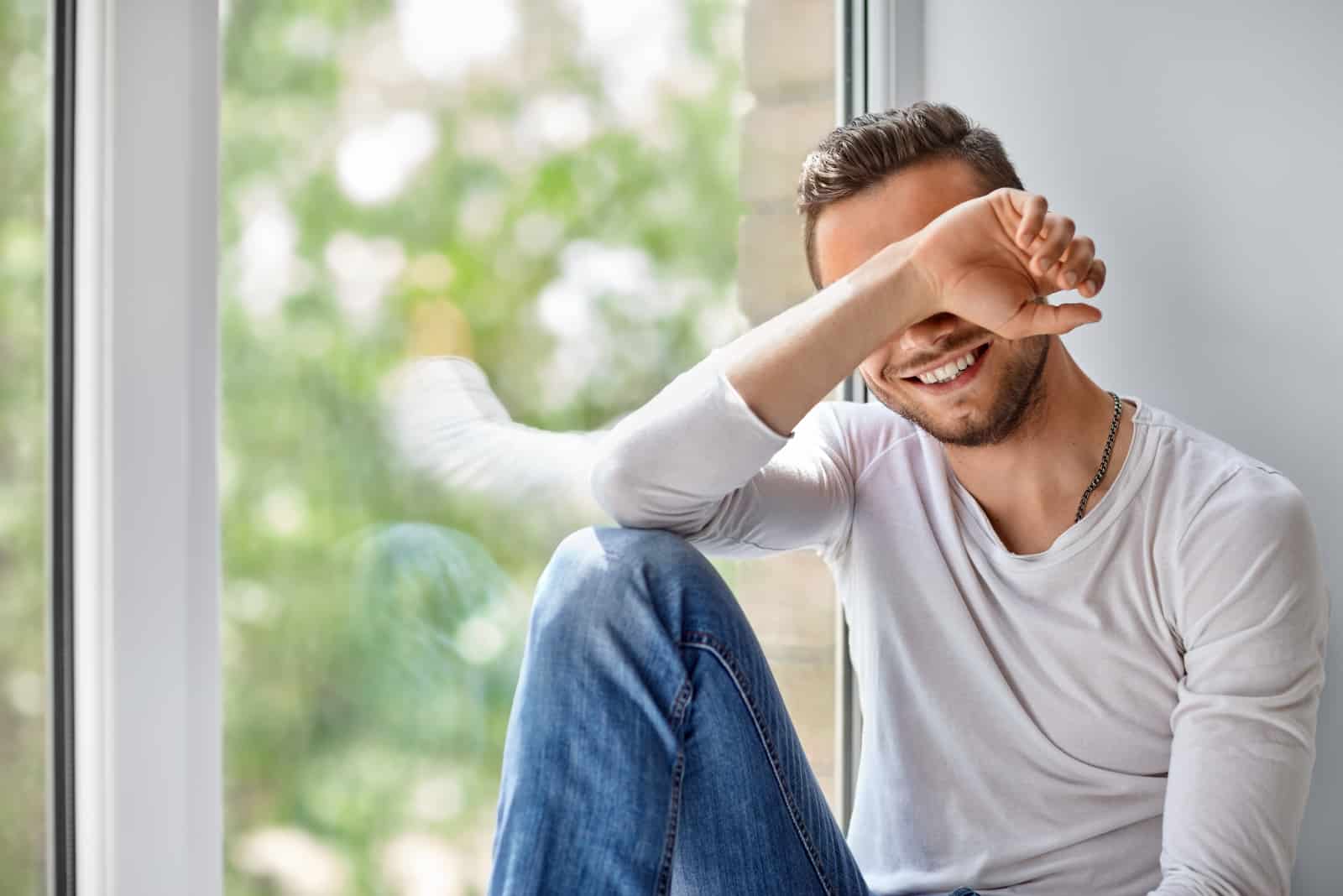 schüchterner Mann, der am Fenster sitzt