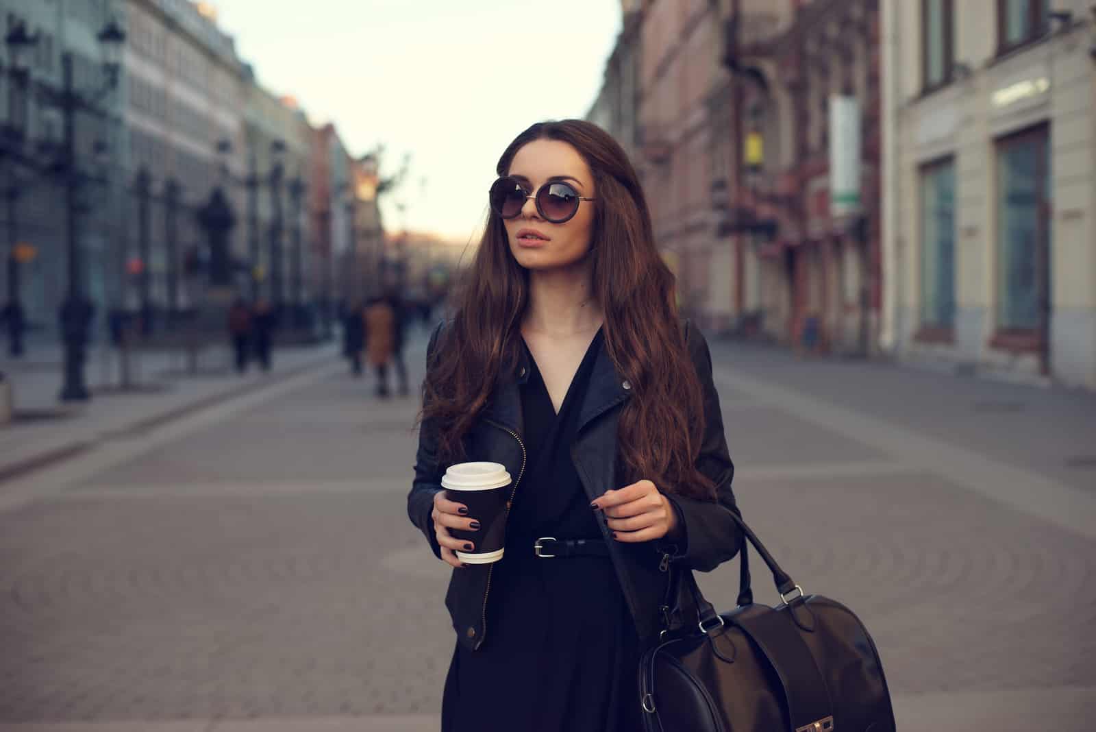 Eine schöne Frau mit Brille steht auf der Straße