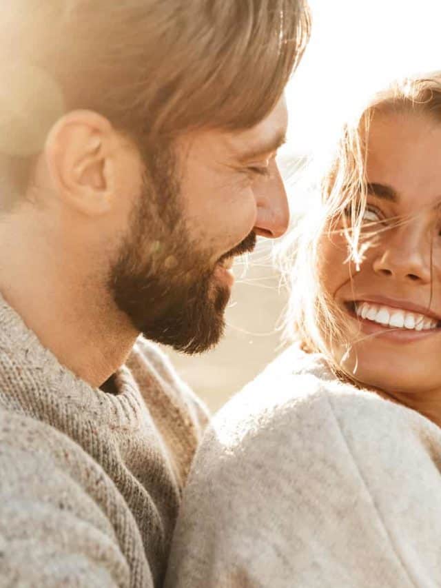 glückliches Paar lächelt sich im Sonnenlicht zu