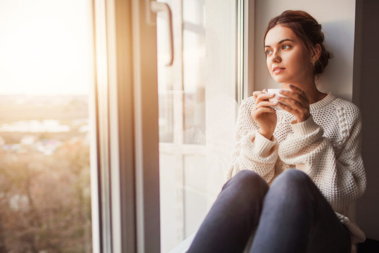 Frau sitzt am Fenster