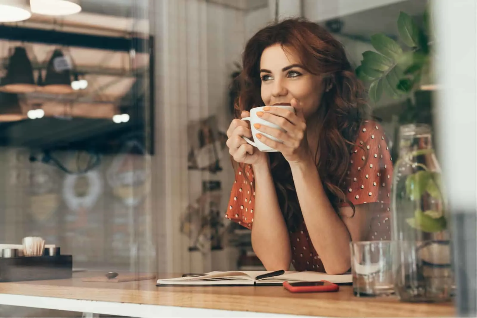 Frau sitzt im Café und trinkt Kaffee