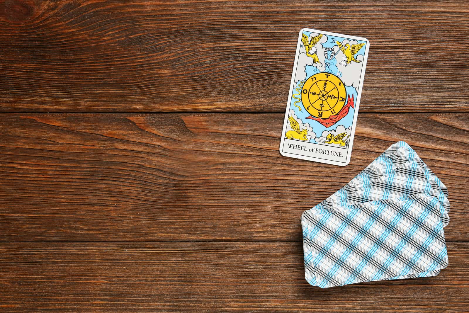 Das Glücksrad und andere Tarotkarten auf einem Holztisch