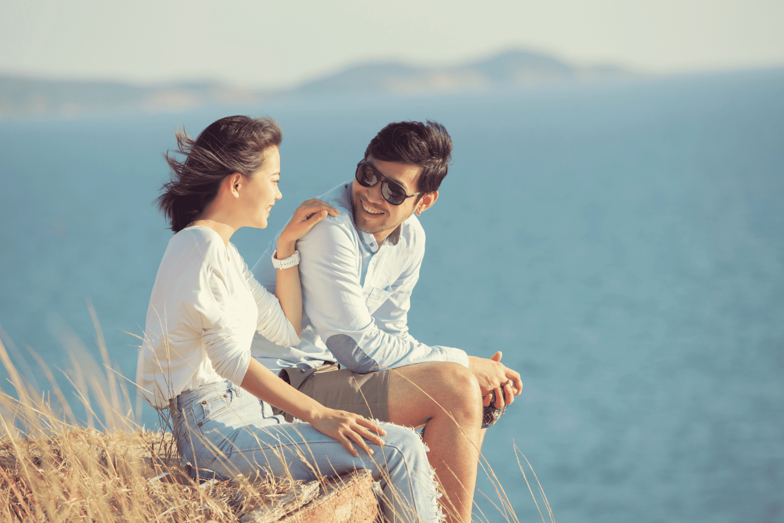 Ein Mann und eine Frau sitzen auf einem Felsen und unterhalten sich 