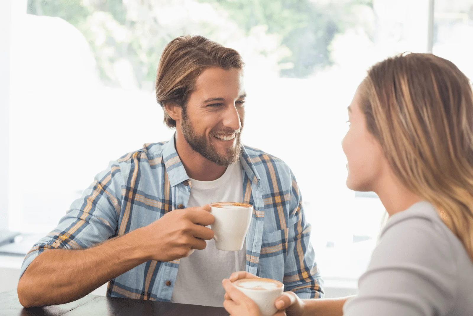 Ein lächelnder Mann spricht mit einer Frau beim Kaffee