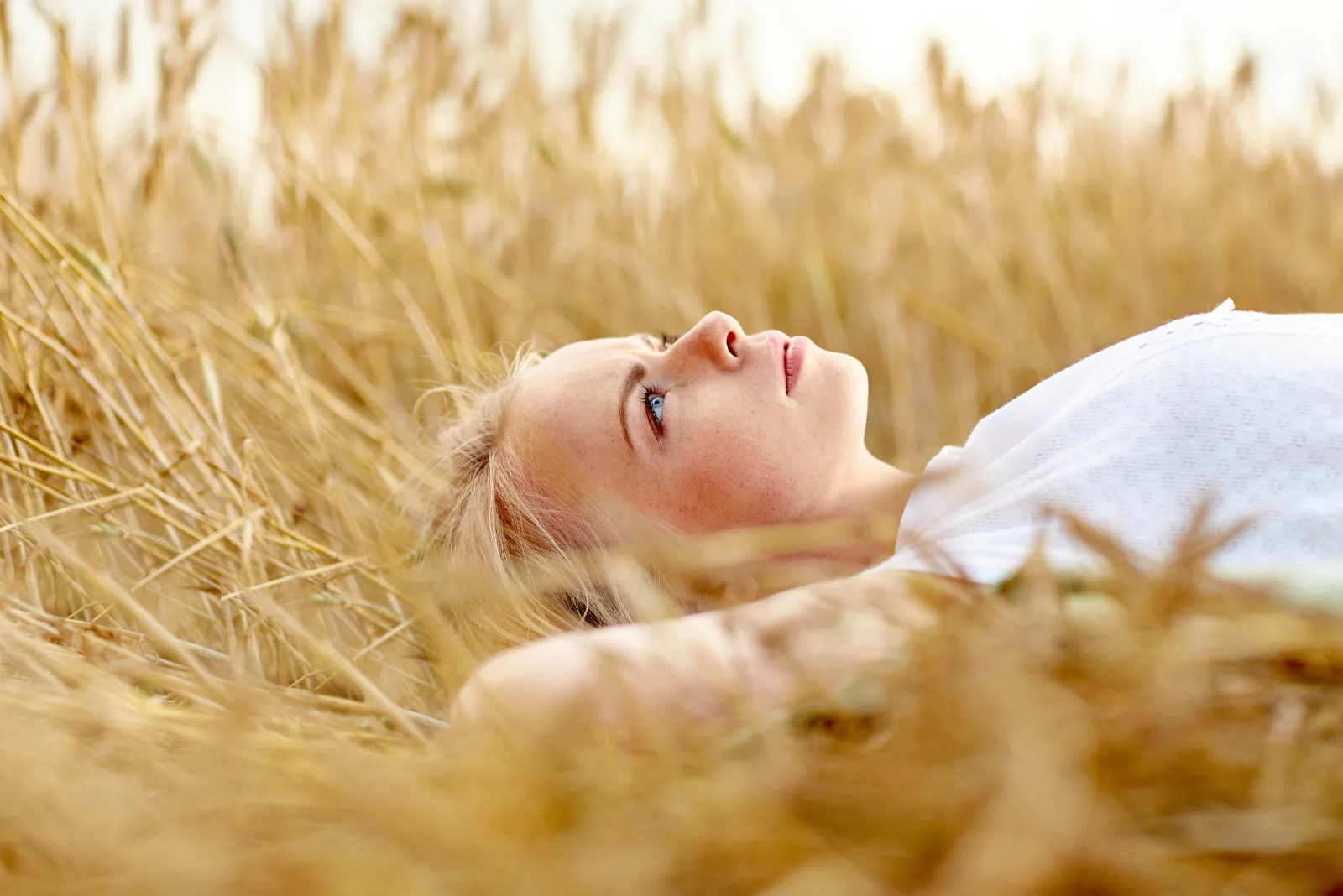 Eine Frau liegt in einem Weizenfeld