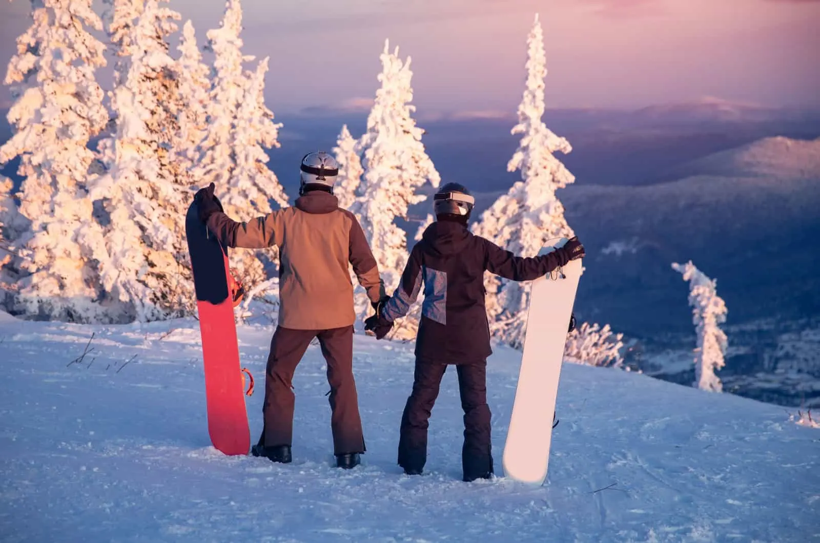 Ein paar Snowboarder halten sich an den Händen