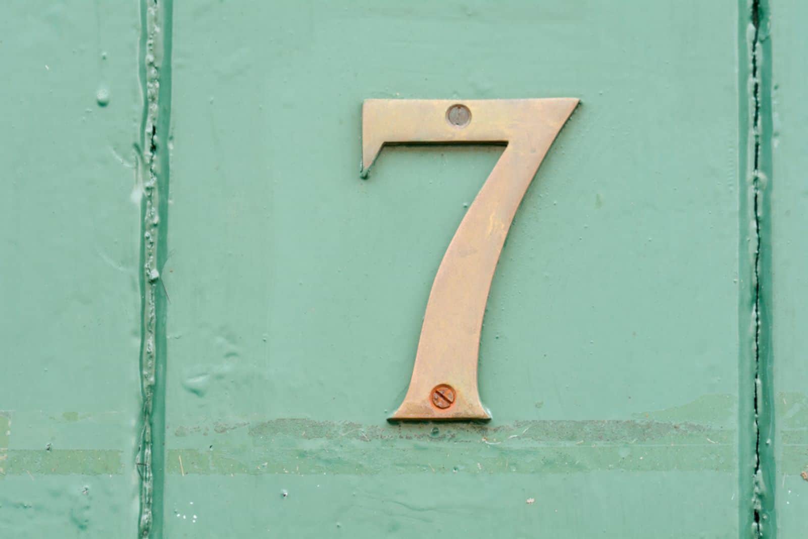 Hausnummer 7 Schild an grün lackierter Tür
