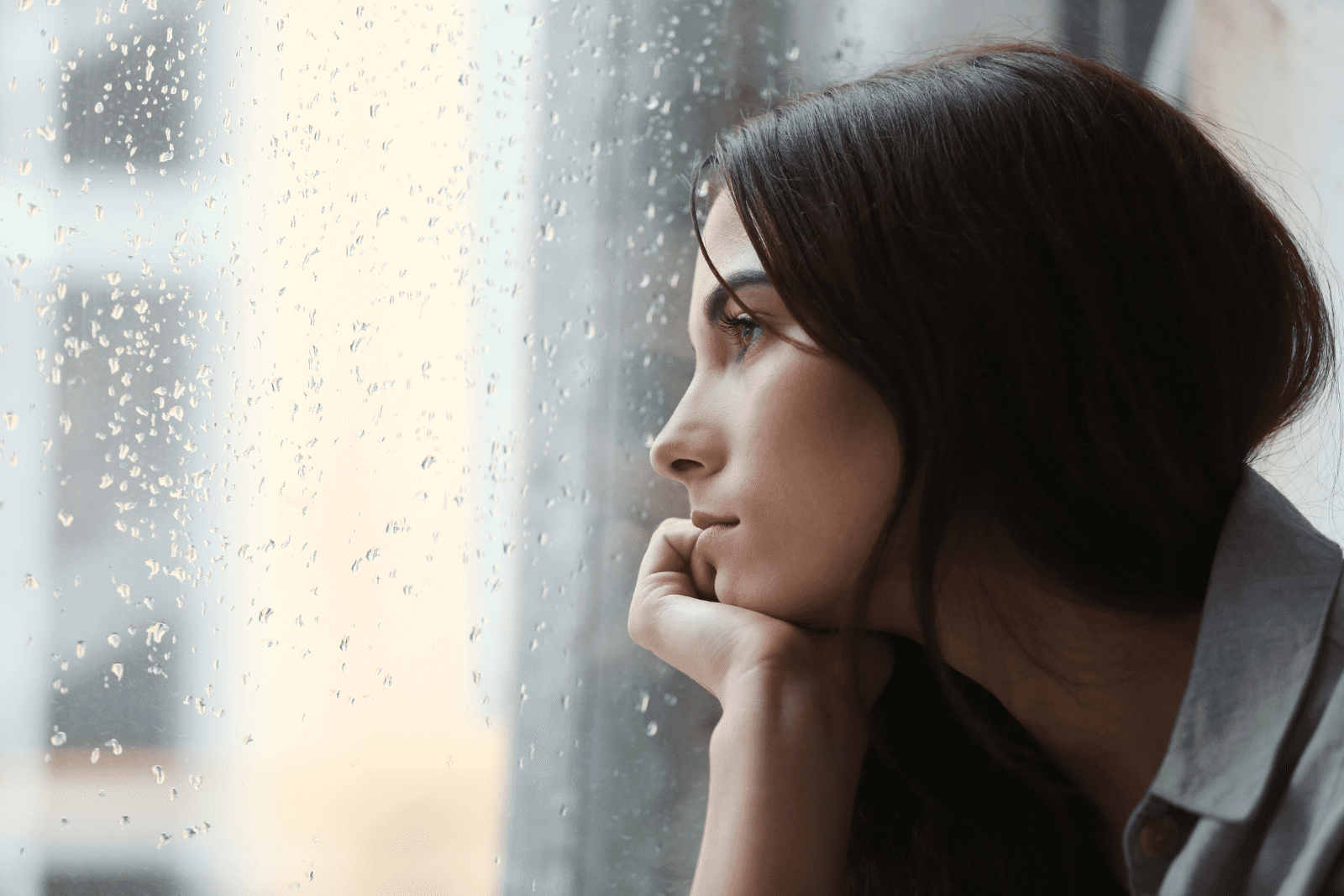 traurige Frau schaut aus dem Fenster
