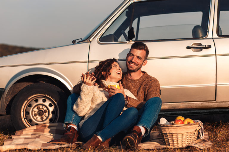 mann und frau sitzen vor auto
